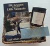 Basket with book 'BIG Lessons from Life's Little Moments'  candle, and decorative item on a light gray background. gift bundle