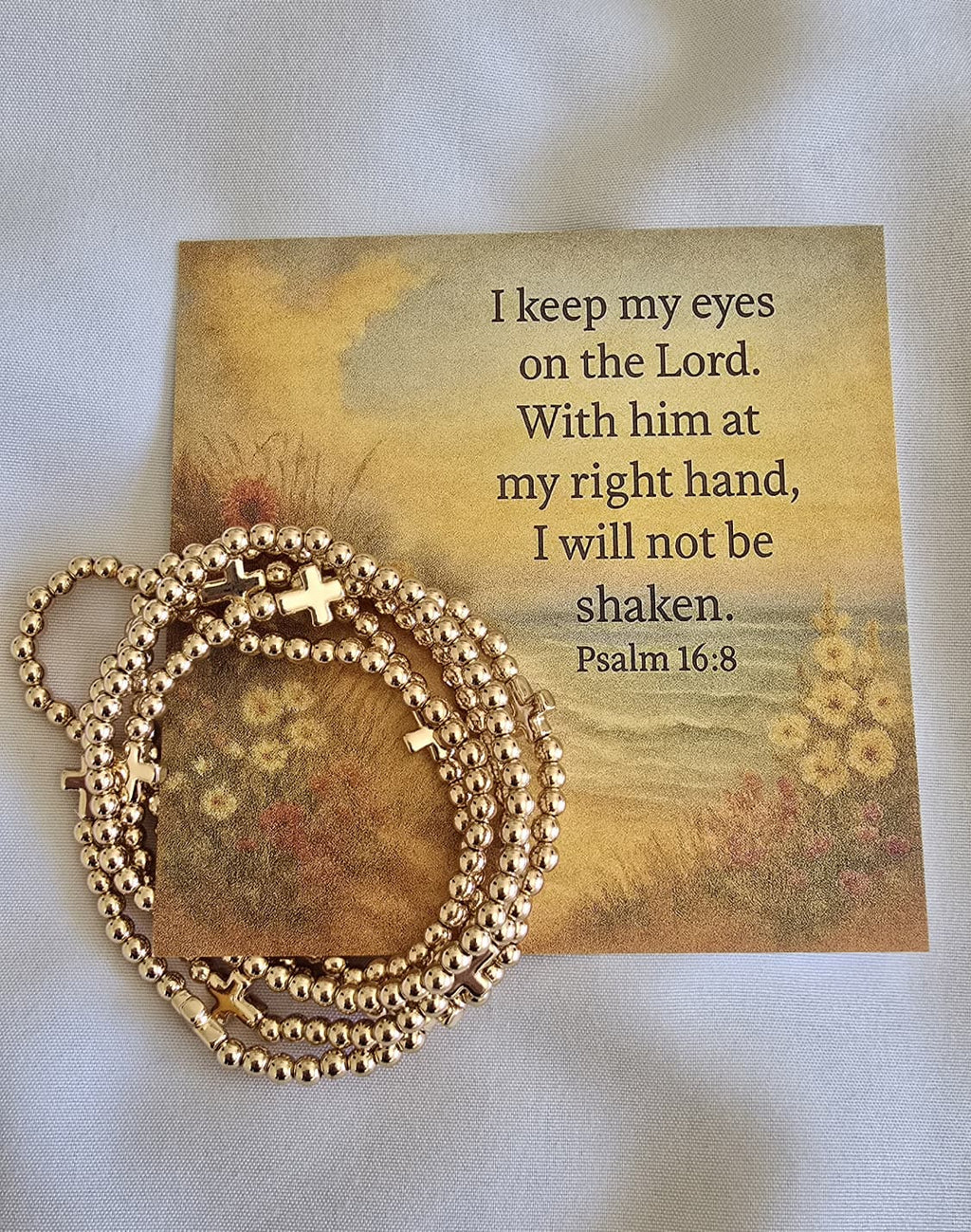 Brass cross and brad bracelets on scripture card. 