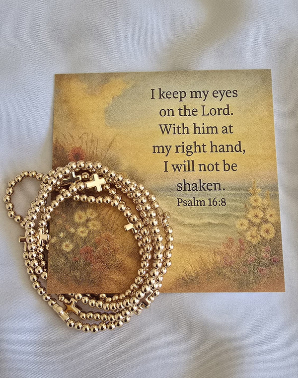 Brass cross and brad bracelets on scripture card. 