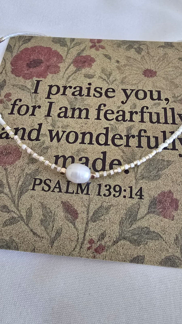 Necklace with a pearl pendant on a card with scripture and floral design