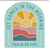 Decorative magnet with a sun and mountains design and text 'Joy Comes in the Morning Psalm 30 Five' on a light blue background.