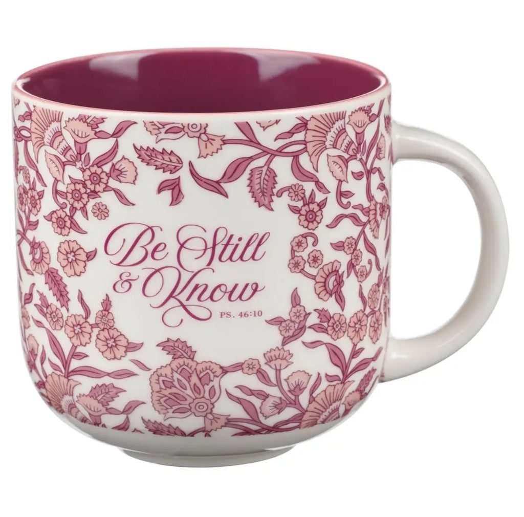 Mug with floral design and 'Be Still & Know' text on a white background