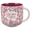 Mug with floral design and 'Be Still & Know' text on a white background