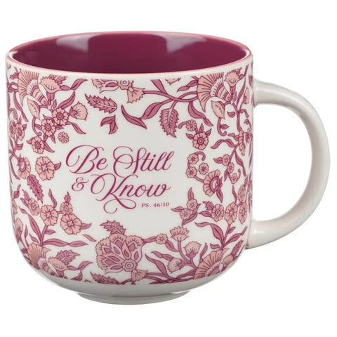 Mug with floral design and 'Be Still & Know' text on a white background
