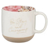 White mug with floral interior, gold text 'Be Strong and Courageous', and beige base on a white background